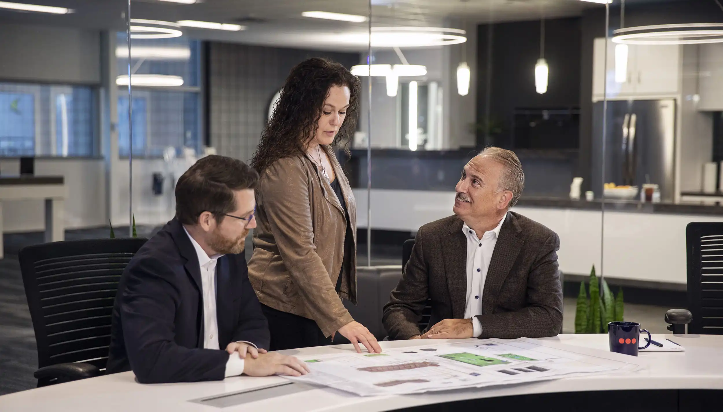 A woman explaining a document to two men.